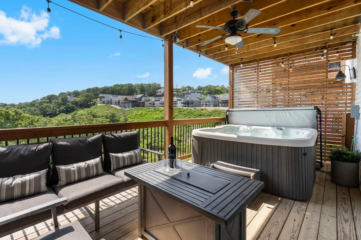 A hot tub sits on a patio with seating and a serene hillside view. The setting is private and tranquil, ideal for unwinding after a day of adventure or exploration, with an open sky perfect for stargazing or soaking at sunset.