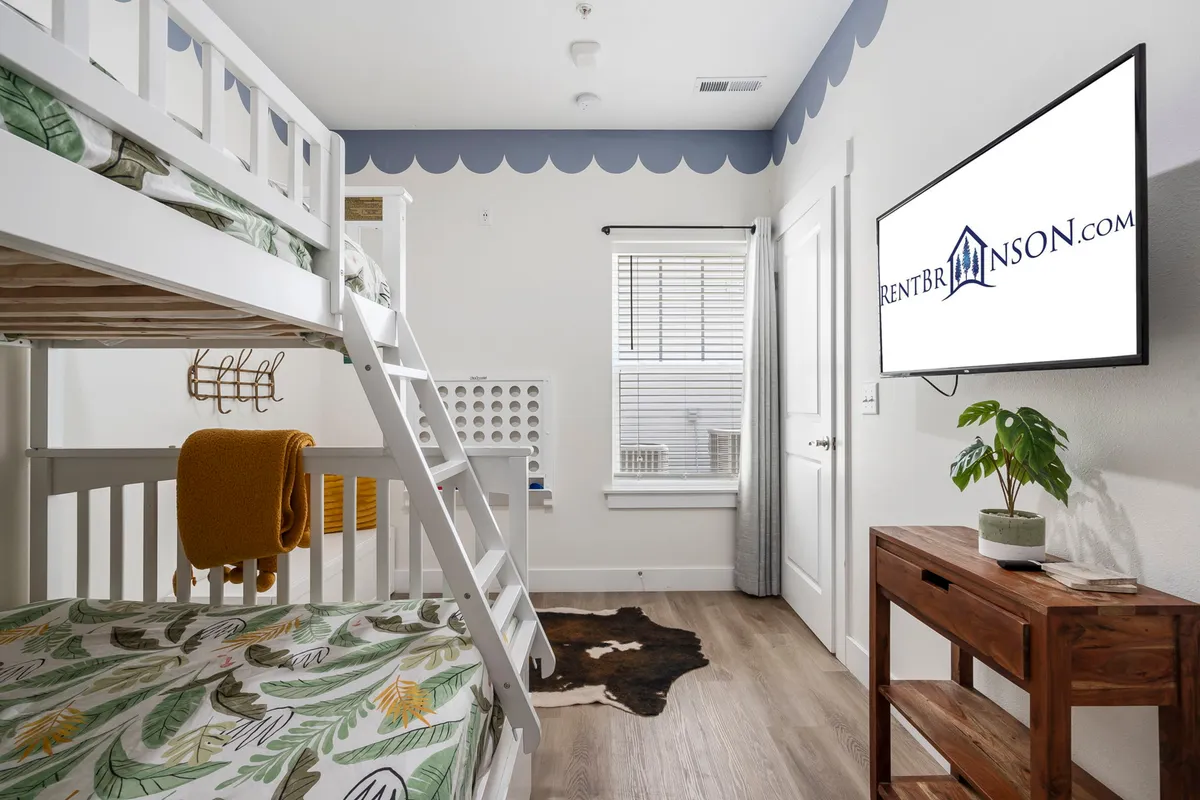 A cozy bunk bed setup with a television and playful decor, designed especially for kids. The space is compact yet comfortable, inviting children to enjoy their own special area within the family zone.
